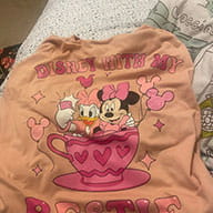 TheFirstLifestyle 36 Customer photo of a peach coloured bestie teacup ride graphic tee laid flat on a bed