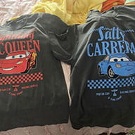 TheFirstLifestyle 39 Customer photo of two matching vintage black race car character tees laid side by side