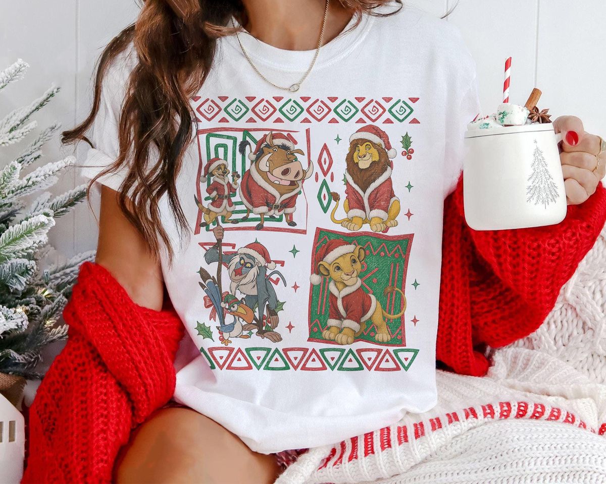 90s simba holiday tee in white layered with chunky red knit cardigan and christmas mug for cozy theme park morning outfit