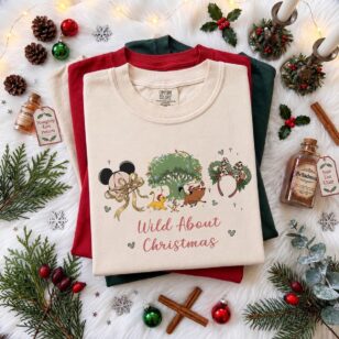 wild about christmas animal kingdom shirt in ivory flat lay with lit tree of life and leopard bow for 2027 holiday trips