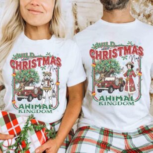 Couple wearing matching customize disney holiday tee walking near Animal Kingdom entrance during Christmas season