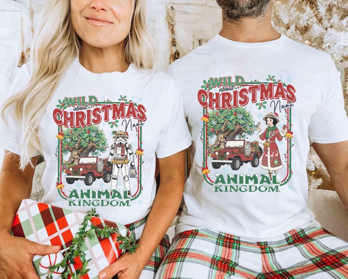 Couple wearing matching customize disney holiday tee walking near Animal Kingdom entrance during Christmas season