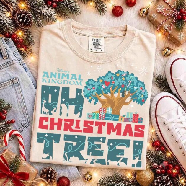Animal Kingdom Oh Christmas Tree Shirt for Holiday Vacations 16 Flat lay of animal kingdom oh christmas tree shirt in sand cotton with holiday pine garland and vintage sneakers