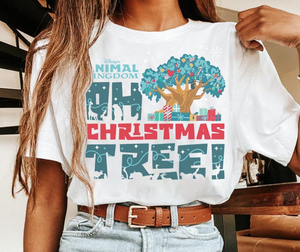 Christmas at Animal Kingdom Secrets Every Traveler Needs for 2027 22 White animal kingdom oh christmas tree shirt tucked into blue denim jeans with brown leather belt