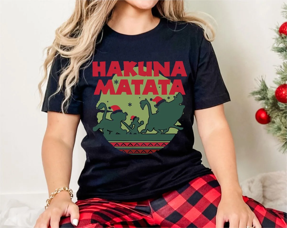 Lion King Hakuna Matata Christmas Sweatshirt with Nordic Art 6 Female model standing indoors wearing black short-sleeve t-shirt with circular Fair Isle Lion King holiday graphic