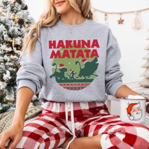 Lion King Hakuna Matata Christmas Sweatshirt with Nordic Art 9 Smiling model indoors wearing heather grey santa simba silhouette crewneck with Nordic Fair Isle savanna artwork