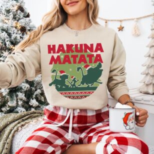 Lion King Hakuna Matata Christmas Sweatshirt with Nordic Art 13 Woman in cozy living room wearing sand tan lion king hakuna matata christmas sweatshirt with red buffalo check lounge pants