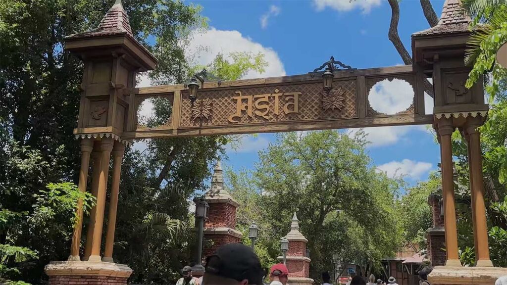 Christmas at Animal Kingdom Secrets Every Traveler Needs for 2027 29 The carved wooden Asia entrance archway with Sanskrit lettering flanked by red brick pagoda pillars at Animal Kingdom