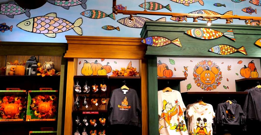 Christmas at Animal Kingdom Secrets Every Traveler Needs for 2027 19 Hand carved wooden fish decor and seasonal Disney apparel displays inside Island Mercantile on Discovery Island