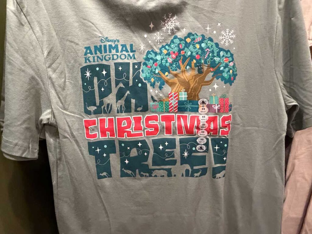 Christmas at Animal Kingdom Secrets Every Traveler Needs for 2027 21 Close up of the screen print graphic showing the Tree of Life with presents and animal silhouettes on the Oh Christmas Tree shirt