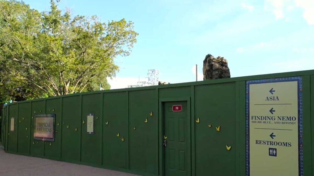 Christmas at Animal Kingdom Secrets Every Traveler Needs for 2027 15 Green construction wall at Disney's Animal Kingdom with directional signs pointing to Asia, Finding Nemo, and restrooms